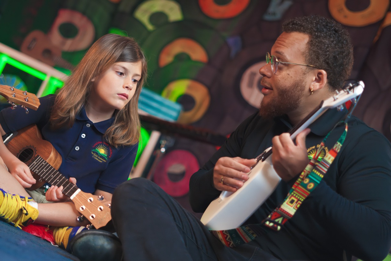 music teacher teaching guitar in elementary school
