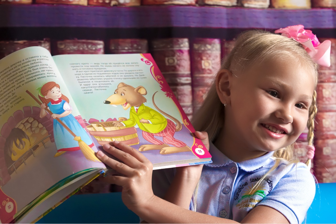 girl reading a book in preschool